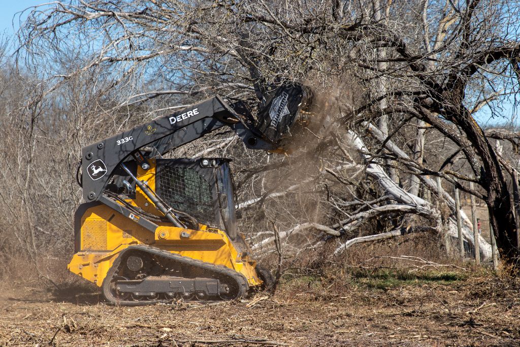 Land clearing equipment removing large trees